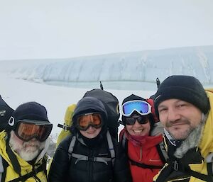Four people selfie with a glacier in the background