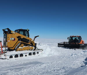 Snow groomer and skid steer on a plateau of ice