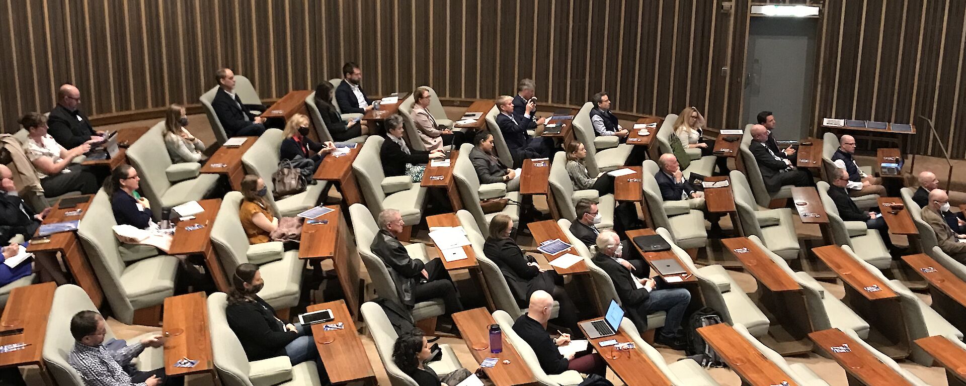 An auditorium full of people seated.