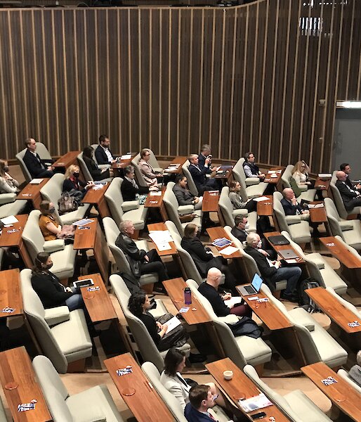 An auditorium full of people seated.
