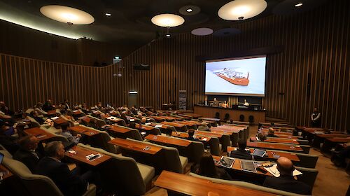 A auditorium with a picture of Australia's icebreaker RSV Nuyina on the screen