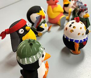 Selection of painted plastic penguins in group on table