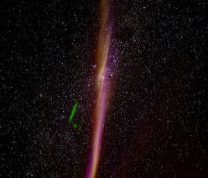 A pinkish-white arc in the night sky.