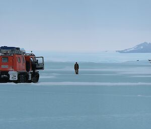 A red vehicle is stopped in the snow with someone looking for the way forward