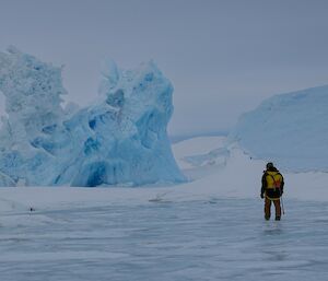 A person walks towards an iceberg