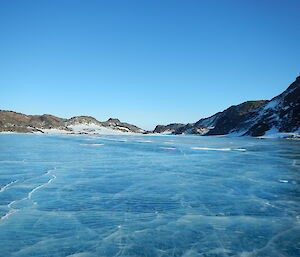 A bright blue frozen lake with blue skies
