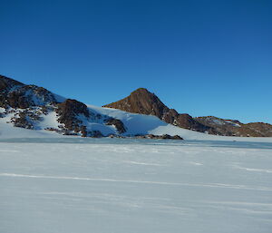 landscape of snow with rocks and hills in the background