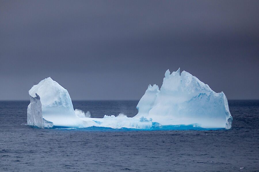 A medium sized iceberg in the middle of the ocean