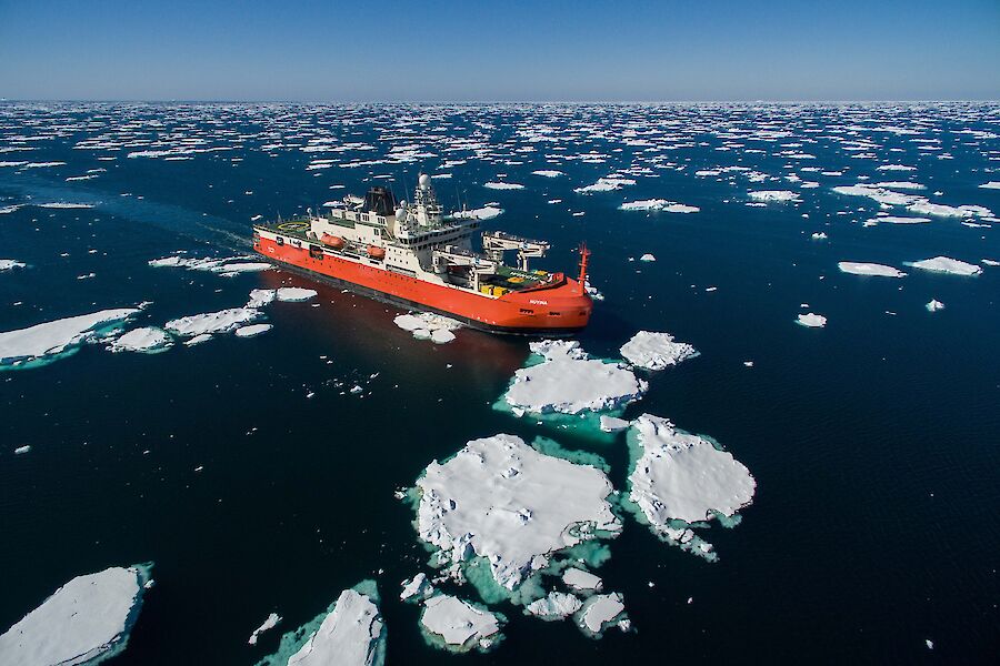 An aerial shot of a ship surrounding by large bits of ice