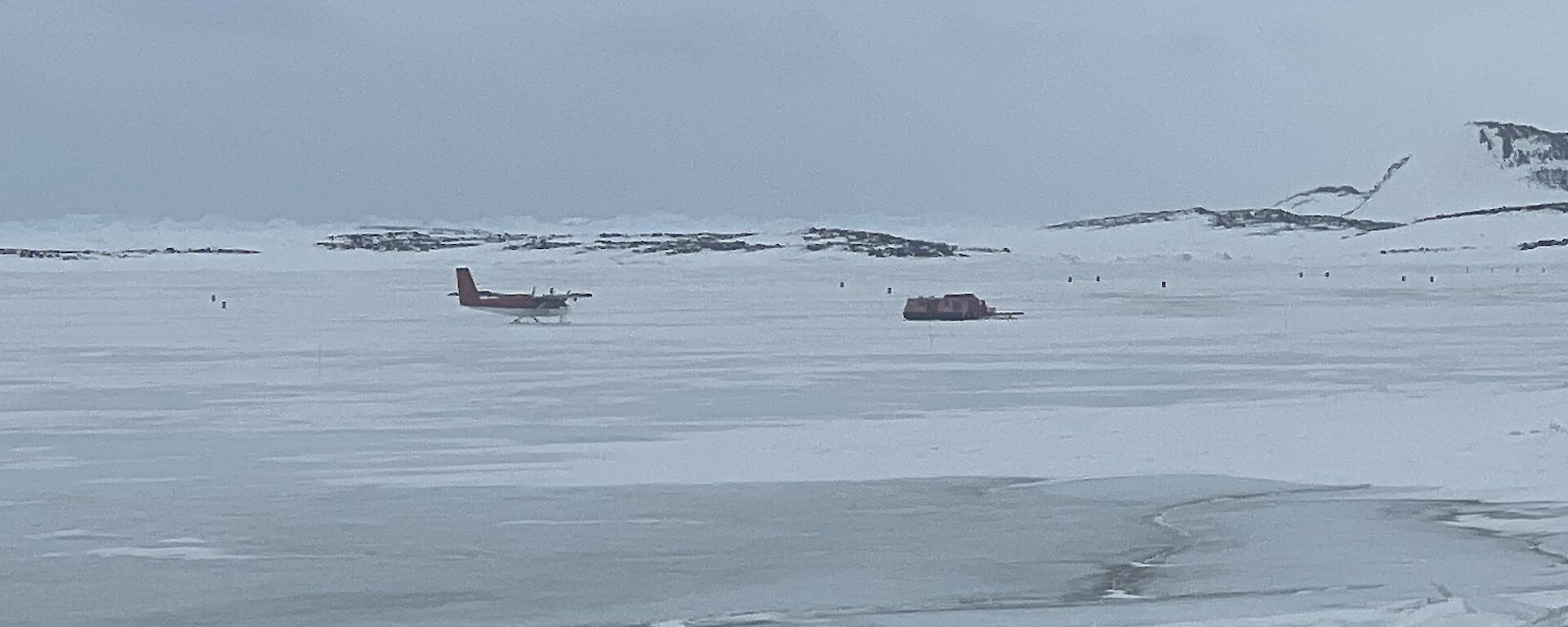 A plane approaching a sea ice runway on a grey day