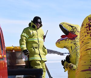 Two people in dinosaur costumes welcome a new expeditioner