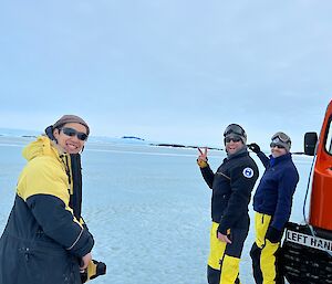 Three expos smile at camera, sea-ice expanse in background