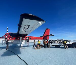 Twin Otter offloading cargo into back of ute