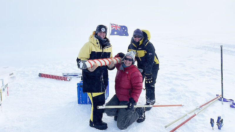 Three women carry an ice core in Antarctica