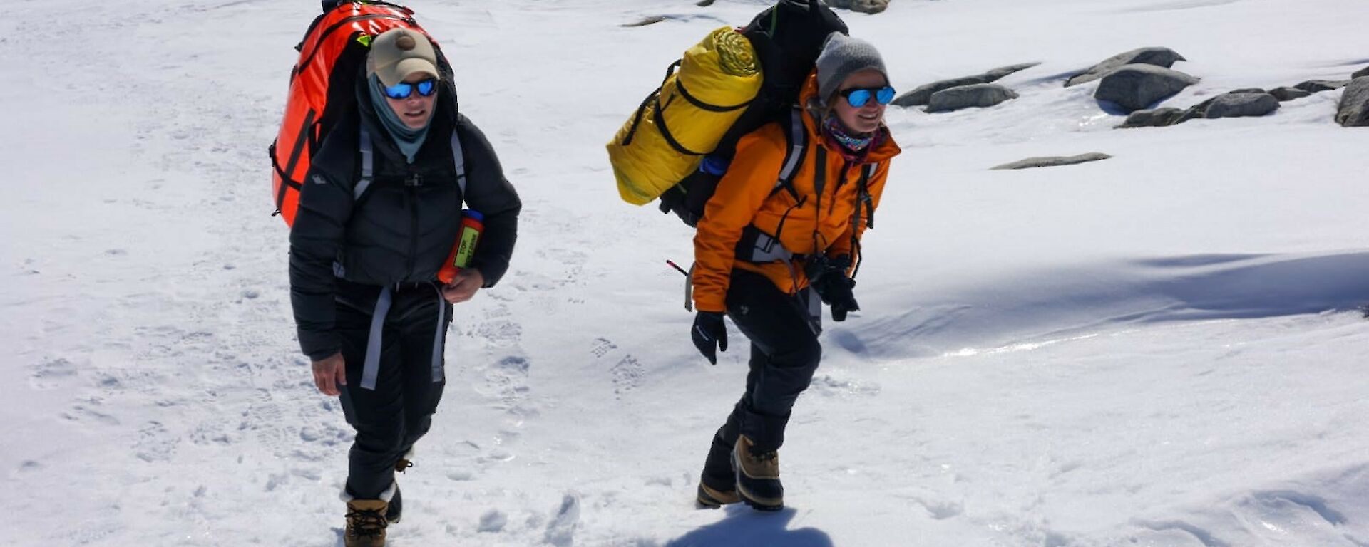 Two people trekking through snow