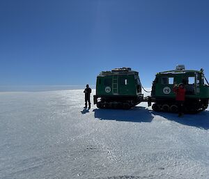 A person standing beside a Hägglunds vehicle on the ice cap