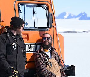 Two people relaxing in the sun with the Mawson mountains in the background