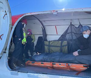 A person lies inside a plane and gives the thumb up sign