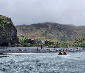 A small boat approaches the shore to collect waiting people