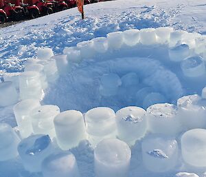 Base of the igloo being built, round ice blocks ready to be put onto next level of construction