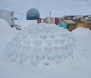 Finished igloo with snow cover and station buildings behind