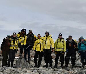 Group of people in Antarctic clothing standing on rock