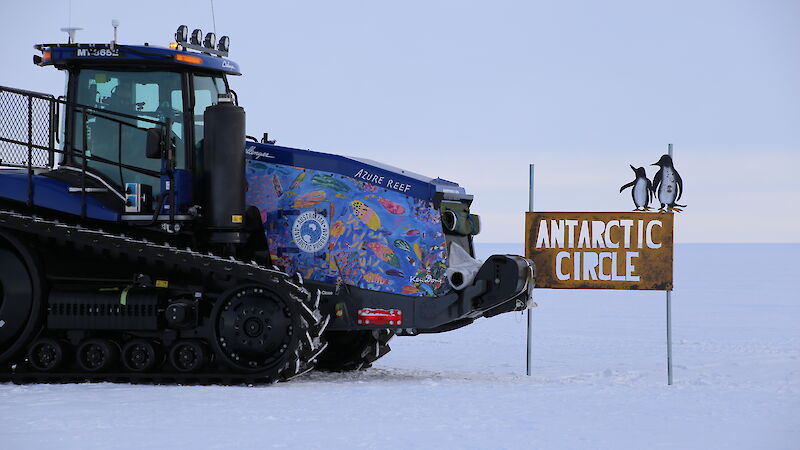 Antarctic tractor on an ice runway next to the Antarctic Circle sign