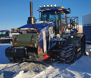 A tractor pulls a container of sleds across the ice.