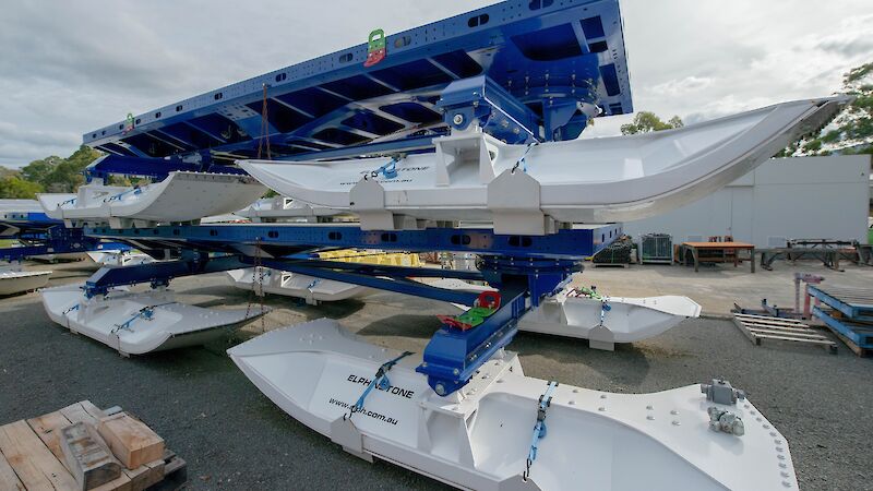 Large blue and white sleds with 'Elphinstone' stencilled on the side sitting outside a warehouse.