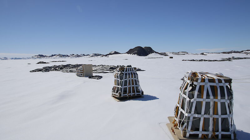 Square loads of cargo sitting on the ice after an airdrop.