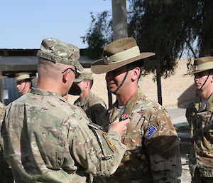 A man receives a medal in a military ceremony