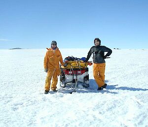 Two men posing next to a quad bike in Antarctica