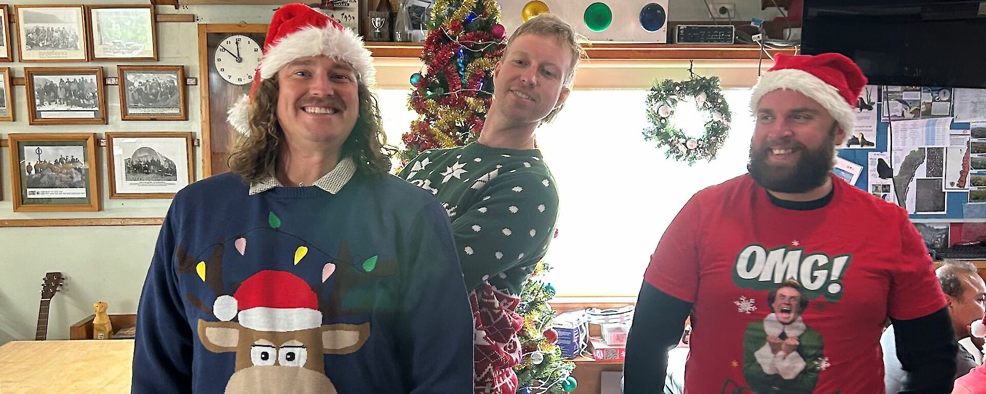 Three men in Christmas outfits smiling