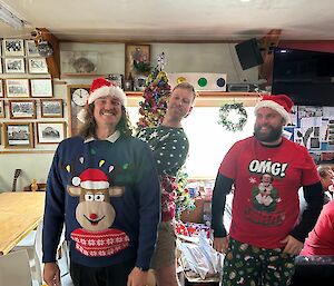 Three men in Christmas outfits smiling