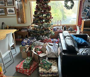A Christmas tree with lots of presents under it