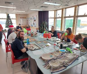 People sitting at long table decorating gingerbread men and shapes