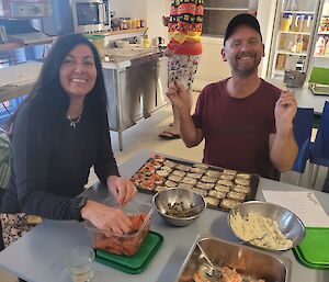 Two people happily making Christmas hors d'oeuvres