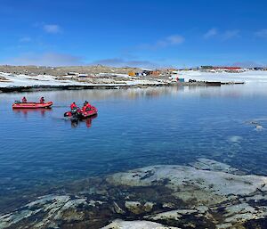 Small boats on the water laying ropes to catch drifting ice.