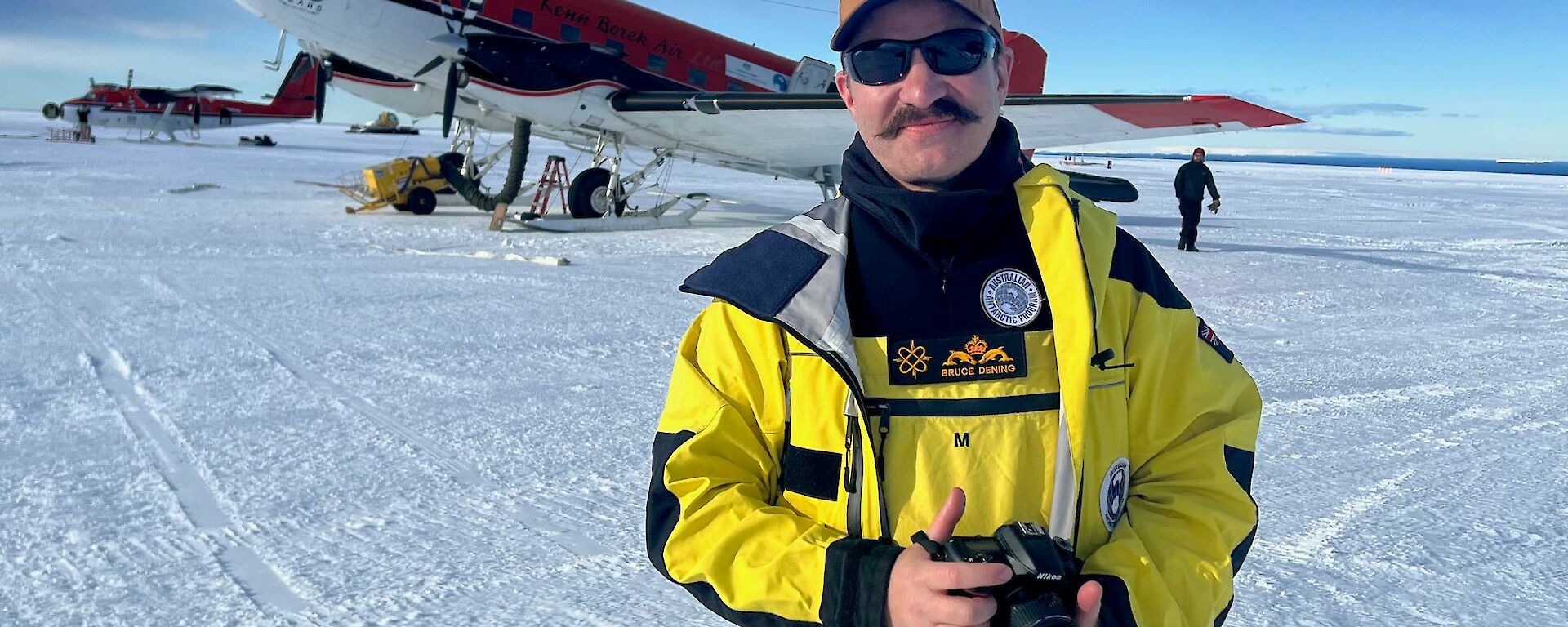 Antarctic expeditioner standing in front of DC-3 aircraft
