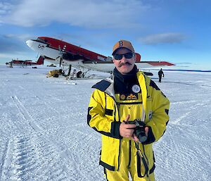 Antarctic expeditioner standing in front of DC-3 aircraft
