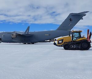 A Boeing C-17 Globemaster parked on ice with a refuelling tractor in the foreground