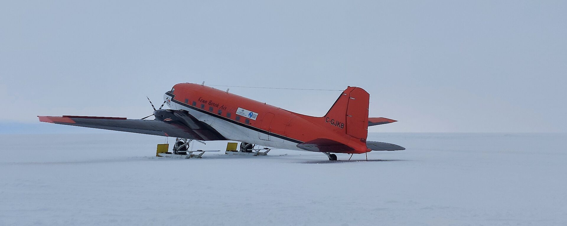 Red Basler aircraft parked on snow