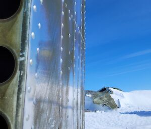 Looking along side of aircraft tail toward fuselage sticking up out of the ice