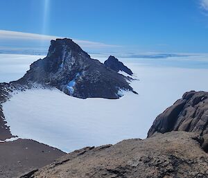 Looking down along mountain range, with ice plateau and ocean in the distance