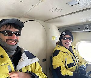 The author and her colleague seated in an aircraft smiling joyfully.