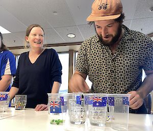 Three people laugh as they play a sorting game on a table