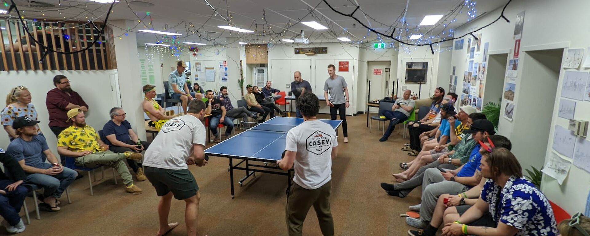 Large crowd watching a doubles table-tennis game