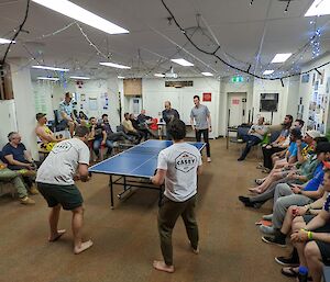 Large crowd watching a doubles table-tennis game