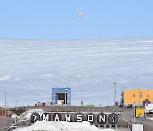 A weather balloon flies above the station sign that says Mawson