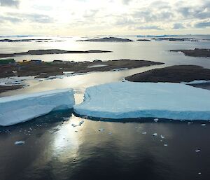 Icebergs float in the ocean with the sun shining down